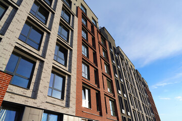 Fototapeta premium Facade building. Modern building and houses against blue sky. Colorful buildings with glass windows, balconies. Buildings architecture. Skyline Skyscrapers. Urban Residential building exterior.