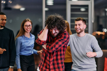 A group of young business people have fun playing interesting games while taking a break from work in a modern office. Selective focus 