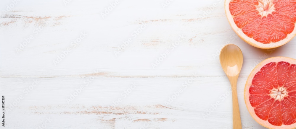 Poster a grapefruit on a white wooden surface with a spoon beside it, showcasing a copy space image.