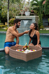 man and woman having breakfast in the pool