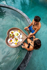 man and woman having breakfast in the pool