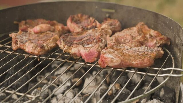 Mięso skwierczy na rozpalonym grillu, zbliżenie na ruszt 