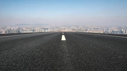 Fototapeta premium Endless Asphalt Road Leading to Urban Skyline