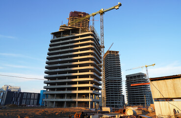 Fototapeta premium Construction site. Construction of Skyscrapers. Tower Crane on formworks. Construction of Multi Storey Residential Building. Tower Cranes on Residential buildings Construction. Housing built.
