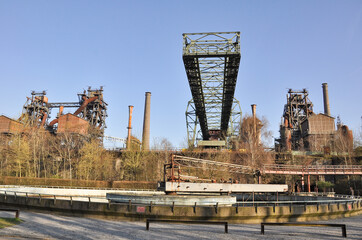 The photograph depicts an old metallurgical plant in Duisburg. Rusty metal structures and pipes...