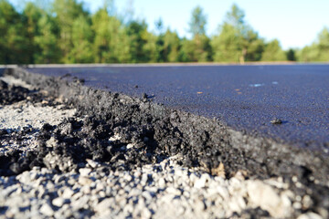 Asphalt road after laying asphalt. New asphalt road renovation. Road construction. Paved sidewalk. Black tarmac pedestrian road, repair. Black tarmac rebuilding. Street Asphalting.
