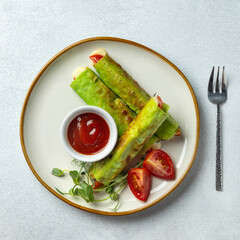 Healthy vegetarian breakfast. Small lavash rolls with spinach, mozzarella and tomatoes with tomato sauce. Light background. Simple recipe. Menu of cafes, restaurants. Snack for children.