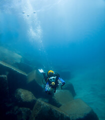 Person scuba diving under the sea with diving equipment