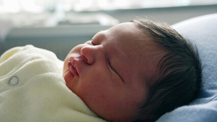 Newborn Baby Sleeping Peacefully on a Blue Pillow, Capturing the Serene and Innocent Moment of Rest...