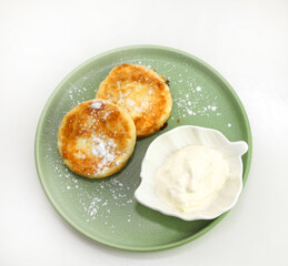 Cheesecakes with sour cream on a green plate