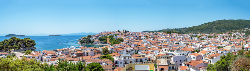 Fototapeta premium Greek island panorama view, Skiathos old town, white washed town houses, Terracotta roofs, seascape with the blue Aegean water. holiday, vacation destination.