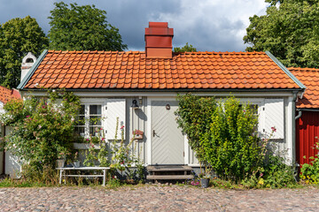 Kalmar a beautiful town in the south of Sweden. Travel touristic Landmark. Traditional little wooden houses. Beautiful small cozy house with clay tile roof. Plants and roses decorates home entre.  © GenоМ.