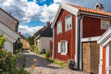 Kalmar a beautiful town in the south of Sweden. Travel touristic Landmark. Traditional little red wooden houses. Beautiful small cozy house with clay tile roof. Plants and roses decorates home entre.  © GenоМ.
