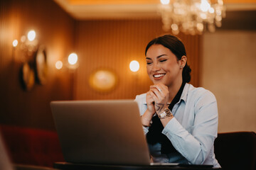 Radiant Latina businesswoman confidently leads business meeting over coffee.