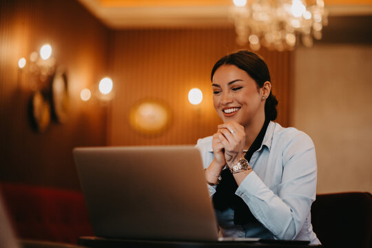 Radiant Latina businesswoman confidently leads business meeting over coffee.