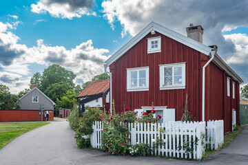 Kalmar a beautiful town in the south of Sweden. Travel touristic Landmark. Traditional little red wooden houses. Beautiful small cozy house with clay tile roof. Plants and roses decorates home entre.  © GenоМ.