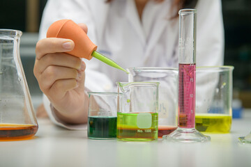 girl scientist loads liquid sample into  with plastic pipette. education and science