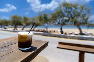 Closeup view of an iced Greek coffee, also known as freddo cappuccino with a straw in Ios Greece