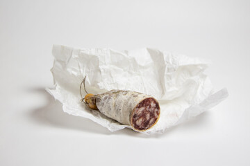 Photographie d'un saucisson coupé sur fond blanc