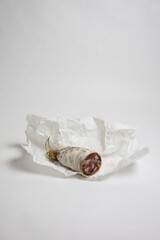 Photographie d'un saucisson coupé sur fond blanc