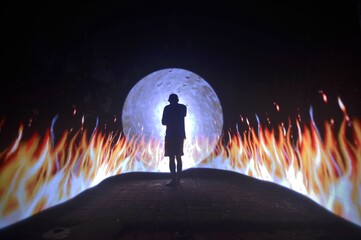 man in the night. One person standing alone against a Colourful circle light painting as the backdrop