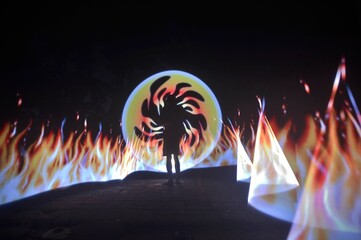 One person standing alone against a Colourful circle light painting as the backdrop