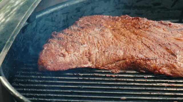 Large tri-tip roast on a barbecue outside 