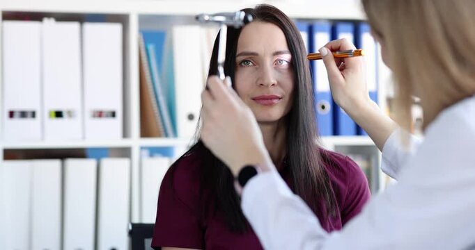 Neurologist shines light into eyes of patient. Diagnosis of neurological diseases of brain concept