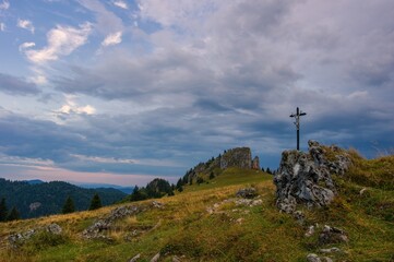 Mountain landscape with rocks, pastures for cattle and a small cross in the foreground. Slovak mountain nature Velka Fatra, Kralova Studna