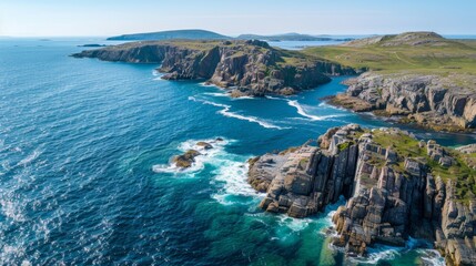 Fototapeta premium Aerial view of rugged northern coastline, waves hitting rocky shore, bright clear day, blue waters