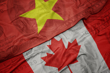 waving colorful flag of vietnam and national flag of canada on the dollar money background. finance concept.