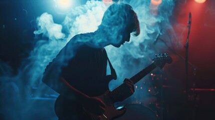 Naklejka premium Silhouette of a young guy playing on the electric guitar on stage in a dark studio with smoke and neon lighting. Slow motion. 