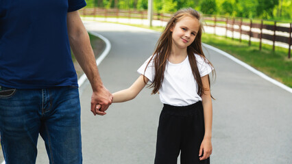 Skating, learning and father holding hands of his child while teaching her on the park. Family, love and dad helping his young girl kid for support, balance and care to outdoor roller skate