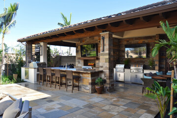 A large patio with a stone fireplace and a grill