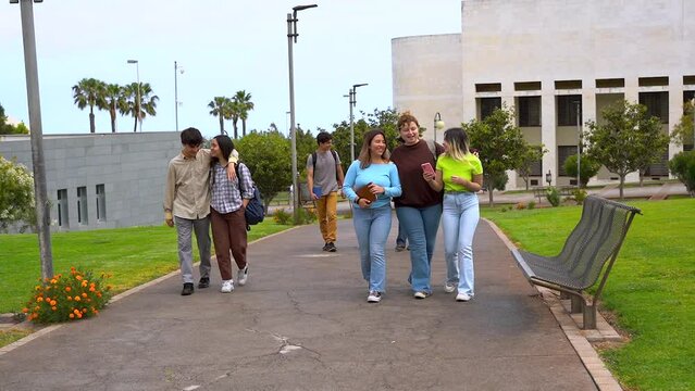 Young students walking together outside of university - School and education concept	