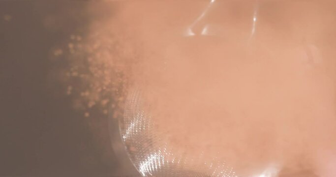 The baker sifts the cinnamon through a fine sieve onto the finished pie.

