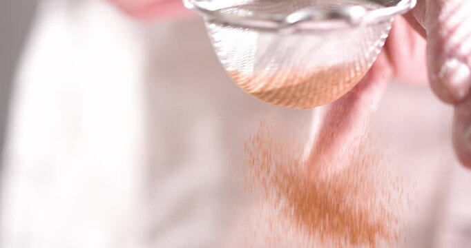Sifting cinnamon onto the finished pie by the baker.
