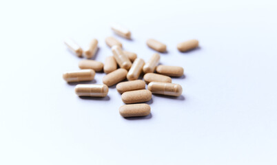 Ashwagandha (Withania somnifera) tablets and capsules on paper background. Soft focus.. Close up. Copy space.
