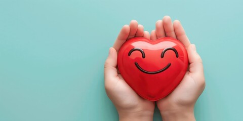 Fototapeta premium Female hands holding red heart with smile face, health care, healthy mind