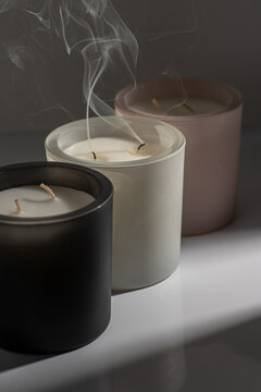 Three candles in pastel colours with smoke and graphic shadows 