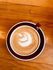 Coffee on a mug with Latte art on wooden table