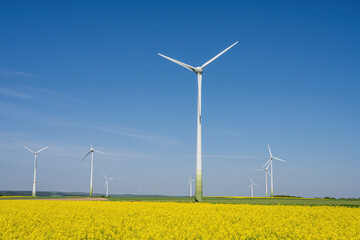Wind turbines and a yellow canola field seen in Germany