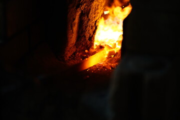 In front of a furnace, Steel burning process, forging the iron steel sword, Close up of burning wood fire in blacksmith furnace