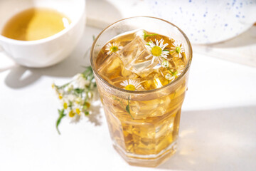 Herbal flower daisy chamomile ice tea, infused aromatic cold drink with daisy camomile wildflower and ice cubes, copy space