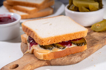 Peanut butter and pickle sandwich with raspberry jam. Sweet and sour unusual taste trendy sandwich with peanut butter, pickles cucumbers and sweet fruit berry jam