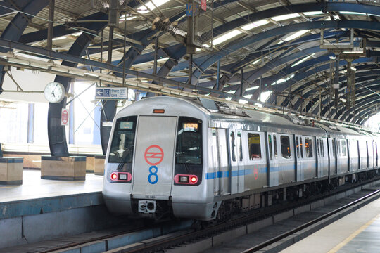 Delhi metro and the metro station. Metro rail in delhi. Dmrc metro entering the station.