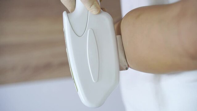 Leg procedure. A professional dermatologist uses modern technology for laser hair removal. The lady undergoes a rejuvenating treatment, enhancing skin health in a well-equipped beauty clinic