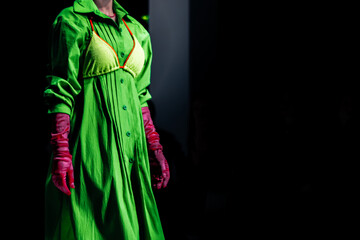 Fototapeta premium Bright green dress, bra and pink gloves. Women's creative fashion design and stylish accessories. Fashion week details