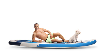 Young man laying on a SUP with a dog