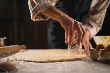 Process of preparing dough for dumplings. Close-up of Cutting circles of dough with a glass